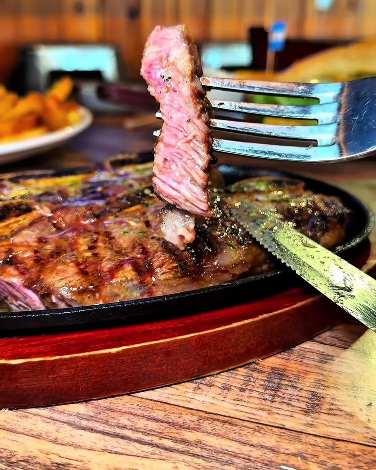 A slice of steak held up on a fork